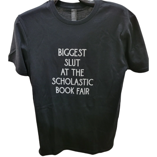 Black t-shirt with white text 'BIGGEST SLUT AT THE SCHOLASTIC BOOK FAIR' on a white background